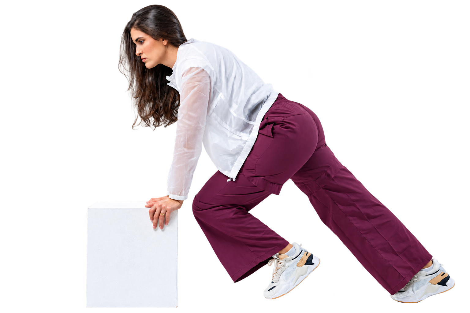 Mayse Resende em uma pose de movimento apoiada em um bloco branco
